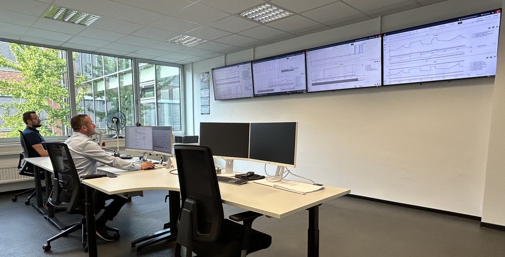 Fleet Control Center: NEA engineers monitoring machine fleets on wall-mounted XPLORE dashboards